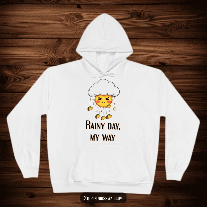 Funny hoodie showing a grumpy cloud raining tacos on a confused sun, perfect for staying cozy and amused with a humorous design.